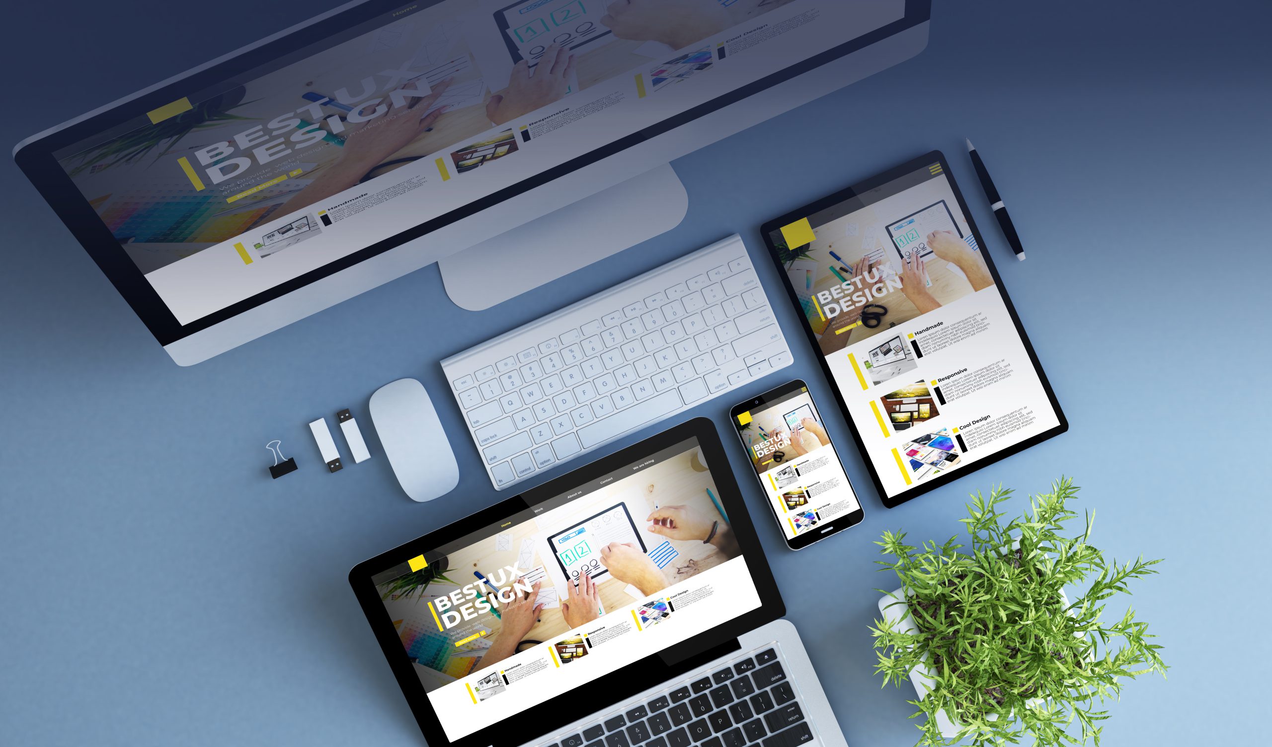 Ein Schreibtisch mit iMac, Tastatur, Maus, Tablet und Smartphone, auf dem eine Website mit der Überschrift „BEST UX DESIGN“ angezeigt wird. Daneben stehen eine Topfpflanze,